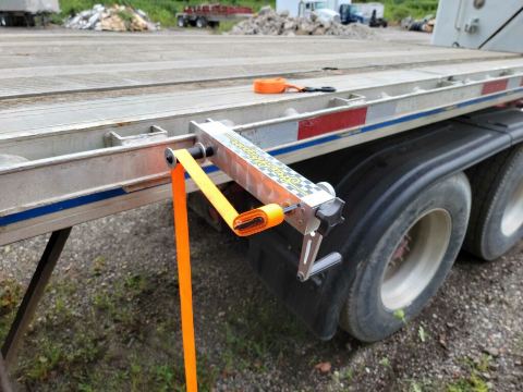 Orange one inch nylon cargo strap being wound onto the StrapWrapper spool