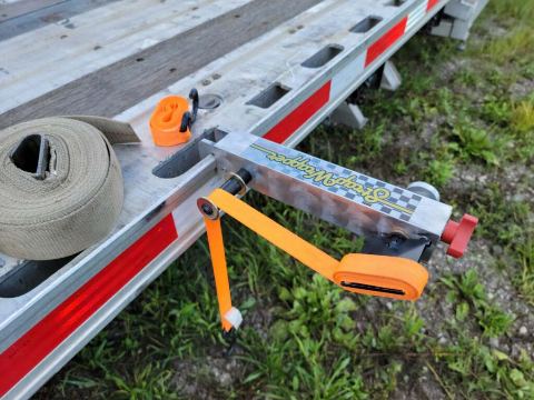 Hand crank turning the StrapWrapper to wind a yellow nylon cargo strap